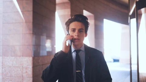 Nice young Caucasian brown-haired man with smartphone speaking, hurrying for Stock Footage 92059633