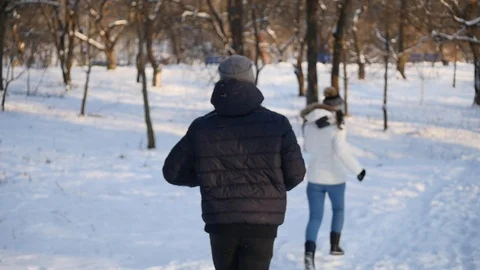 Nice young couple running in the winter forest Stock Footage 87430912