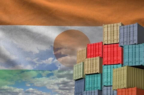 Niger flag and big stack of shipping cargo containers in docks with sky Stock Photos