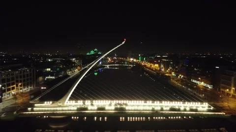 Night aerial of a lit cable-stayed bridge over a river. Stock Footage 327623895