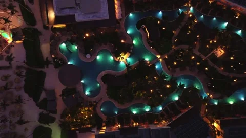Night aerial top down panorama of tourist hotel illuminated pool and park Video stock 274372017