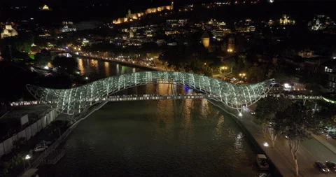 Night aerial view of Bridge of Peace and beautiful cityscape of Tbilisi Stock-Footage 197597130