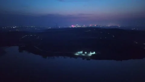 Night Aerial View Over Calm Lake and Rolling Hills Towards City China Stock Footage 338313495