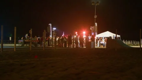 Night beach concert with large crowd, stage lights and summer festival vibes Stock Footage 320128604