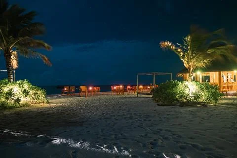 Night beach dining with string lights at a Maldives resort Stock Photos