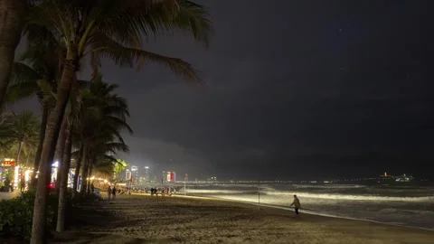 Night beach with ocean waves and city lights in Da Nang, Vietnam Video stock 323928652