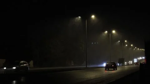 Night, blizzard of snow on the road against a backdrop of burning streetligh Stock Footage 302376580