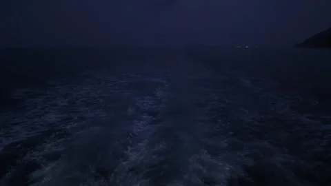 Night boat wake moving on dark ocean water Stock Footage 330196635