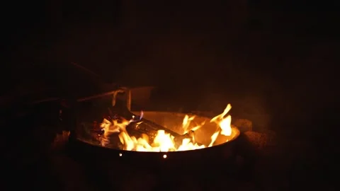 Night bonfire in metal fire pit with burning logs Stock Footage 318738455