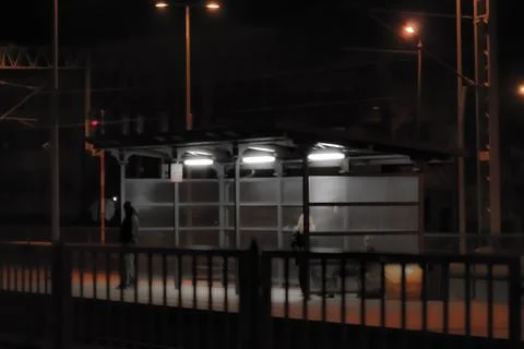 Night bus stop with empty shelter and streetlights Stock Photos