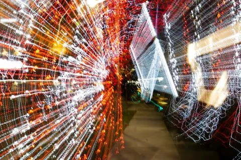 Night city lights diffused with camera motion and zoom out on long exposure. Stock Photos