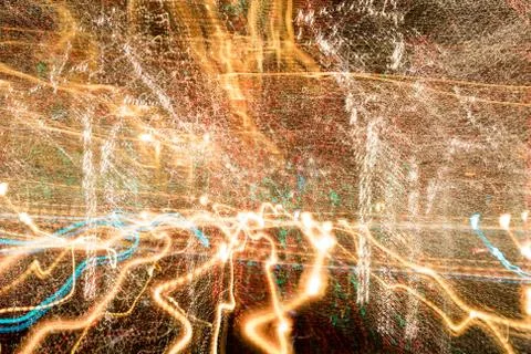 Night city lights diffused with camera motion and zoom out on long exposure. Stock Photos