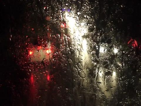 Night city traffic through wet window Stock Footage 80796359