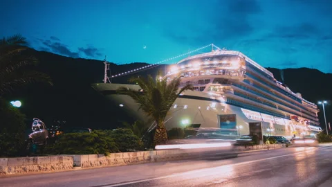 Night city traffic time lapse with large cruise ship docked in port Stock Footage 153906193