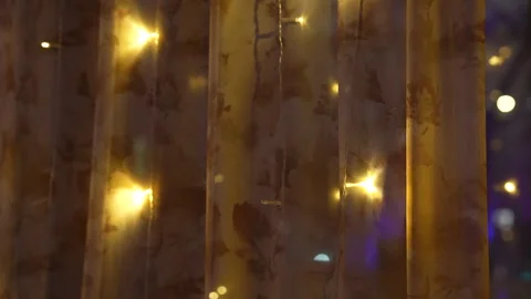 Night city view through window with warm glowing lights on curtains Vídeos de archivo 325802400