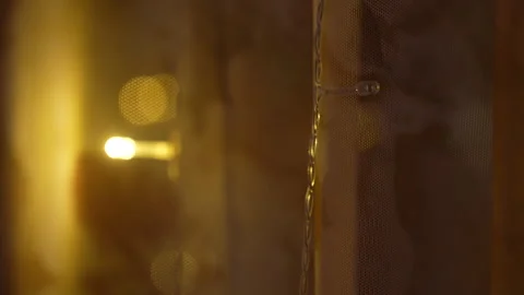 Night city view through window with warm glowing lights on curtains Stock Footage 325802412