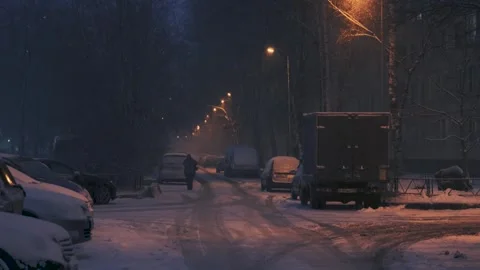 A night city in winter in the evening, falling snow. 4k video. Stock Footage 271675999