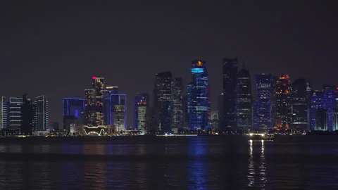 Night cityscape of Doha with architectural skyscraper lights and sea. Stock Footage 339455026
