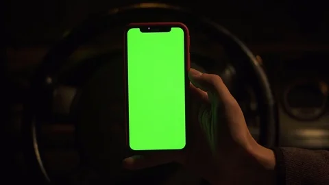 At night close up man hand use vertical green screen in background of blurred Stock Footage 118472759