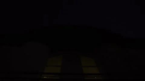 At night, colored lights shine through large window of house. Light blinking. Stock Footage 156483298