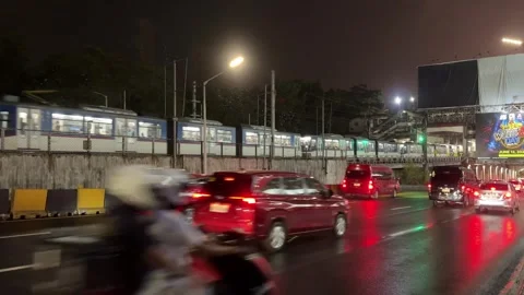 Night commuter train and highway traffic on wet road in Makati 4K Vídeos de archivo 337950469