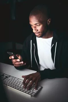 Night, computer and black man with phone for hacking, programming or Stock Photos