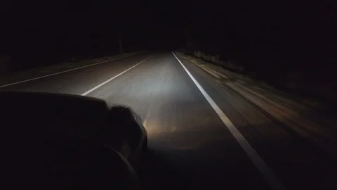 Night country asphalt road. White dividing strip with high beam of car headlight Stock Footage
