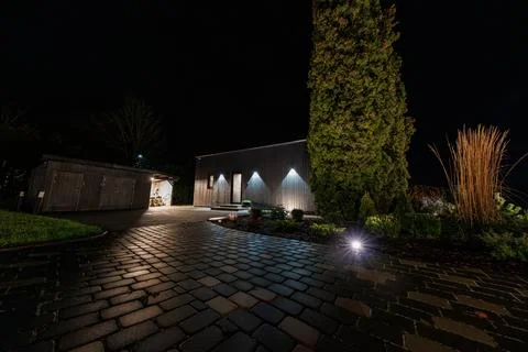 Night courtyard with angular dark timber house and wet cobblestones Stock Photos