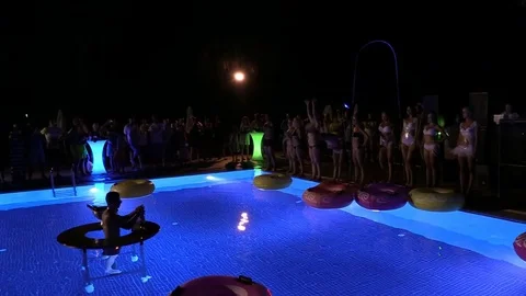 Night crowd active outdoor poolside party Stock Footage 84144762