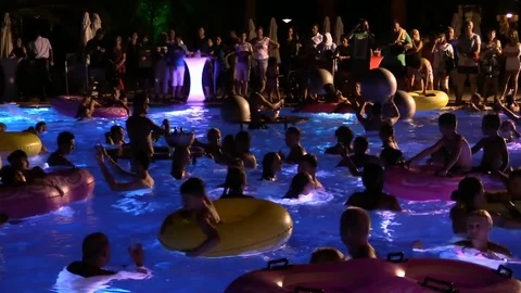 Night crowd active outdoor poolside party Stock Footage 84144793