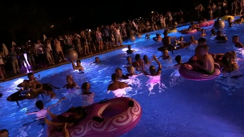 Night crowd active outdoor poolside party Video stock 84144801