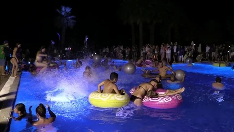 Night crowd active outdoor poolside party Stock Footage 84144806