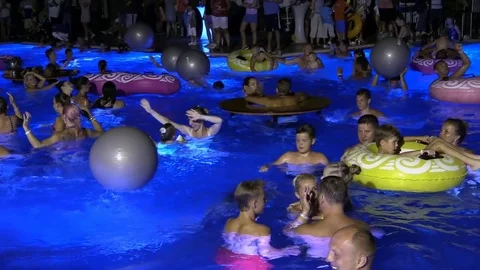 Night crowd active outdoor poolside party Stock Footage 84144834