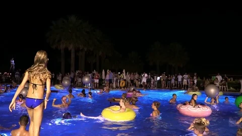 Night crowd active outdoor poolside party Stock Footage 84144836