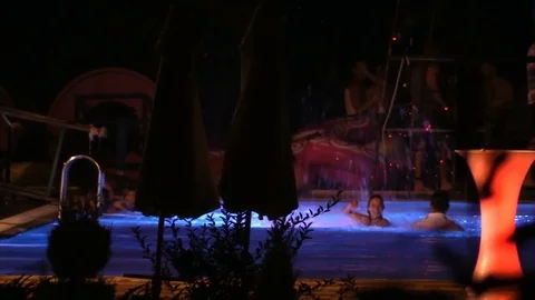 Night crowd active outdoor poolside party pool jump Stock Footage 84144869