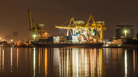 Night to day of  container cargo freight ship with working crane bridge in sh Stock Footage 45010539