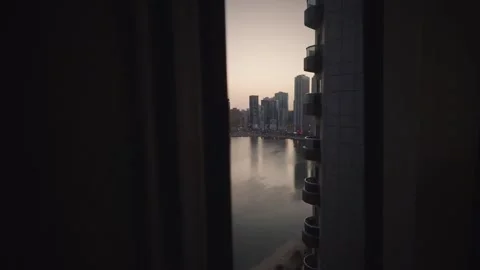 Night to day timelapse from balcony window pov overlooking Sharjah waterfro.. Stock Footage 328530064