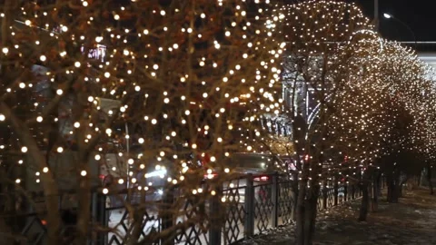 Night decorative illumination on trees by traffic road, christmas garland lights Stock Footage