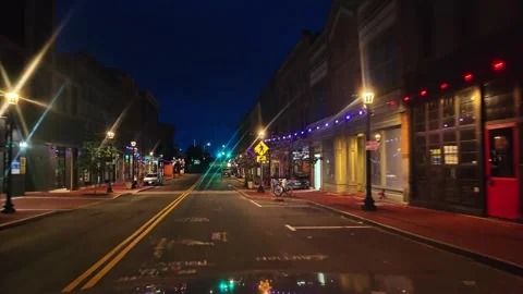 Night driving through charming small town street with illuminated buildings and Vídeo Stock 346097699