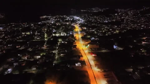Night drone flight parallel to illuminated road in Porto Rafti: Warm Stock-Footage 328999673