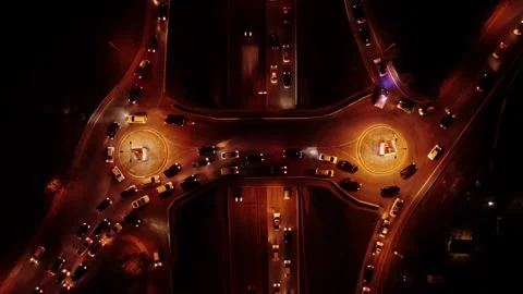 Night drone view of illuminated roundabout with glowing vehicle trails and Stock Footage 343950320
