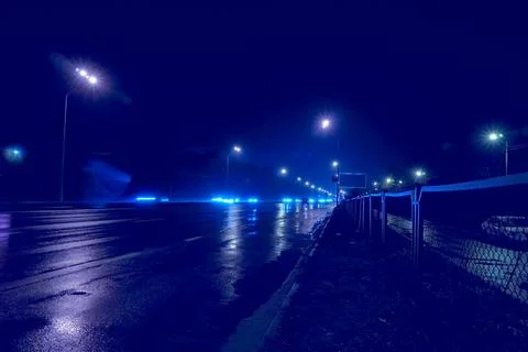 Night empty freeway highway  with wet asphalt and shining blue lights Stock Photos