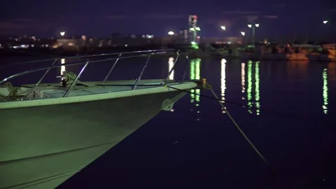 Night, evening, several boats floating on the harbor's sea, sparkling lights and Stock Footage 251700529