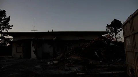 Night falls upon a torn up building Stock Footage 95109394