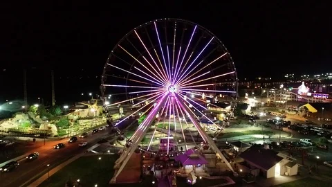 Night Ferris wheel drone elevator shot with LED lit wheel Stock Footage