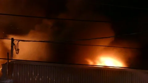 Night fire. A burning fire burns through the roofs of the building. Vídeos de archivo 156881547