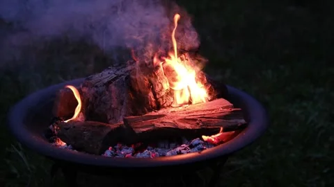 Night Fire Burning in Metal Fire Pit with Glowing Wood and Dramatic Flames Stock Footage 345170492