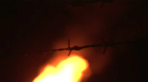 Night flames pull focus barbed wire gas plant Stock Footage 11760009