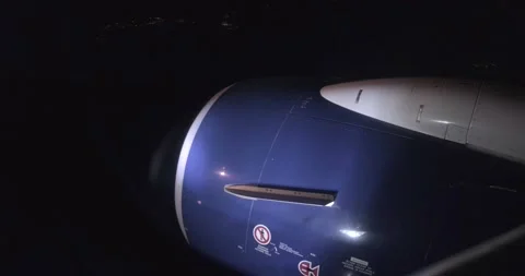 Night flight Airplane engine with lights illuminating dark sky - 4K Video stock 216338085