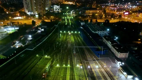 Night flight over the moving trains at Central railway station and the road with Stock Footage 113529477